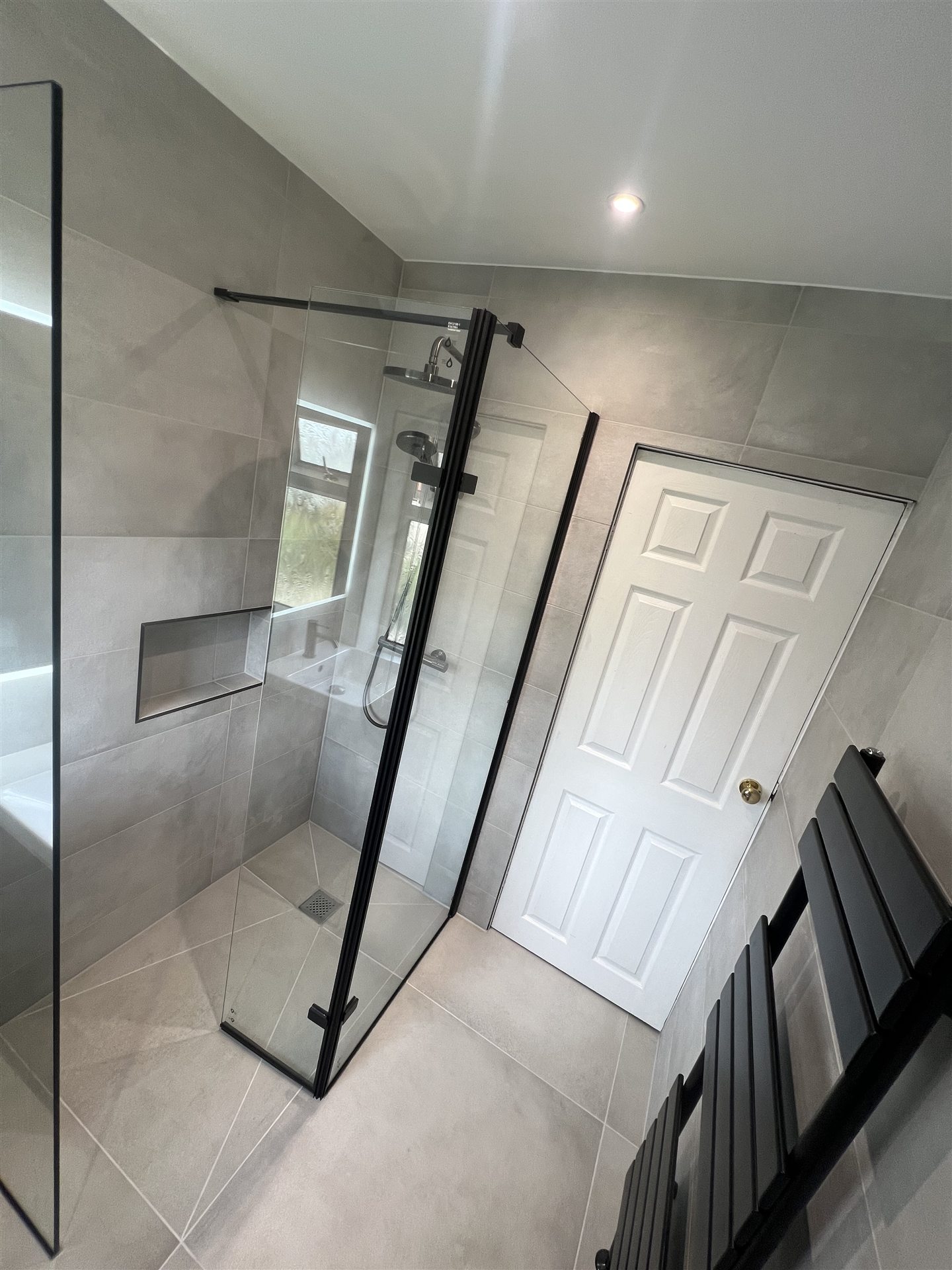 Grey stone-effect bathroom, matte black WC unit and towel rail